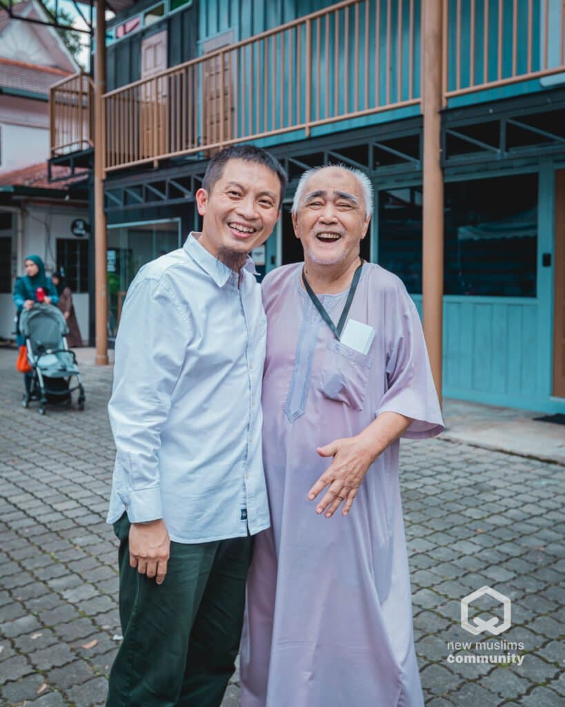 Two men standing arm in arm, smiling broadly at an NMC open day